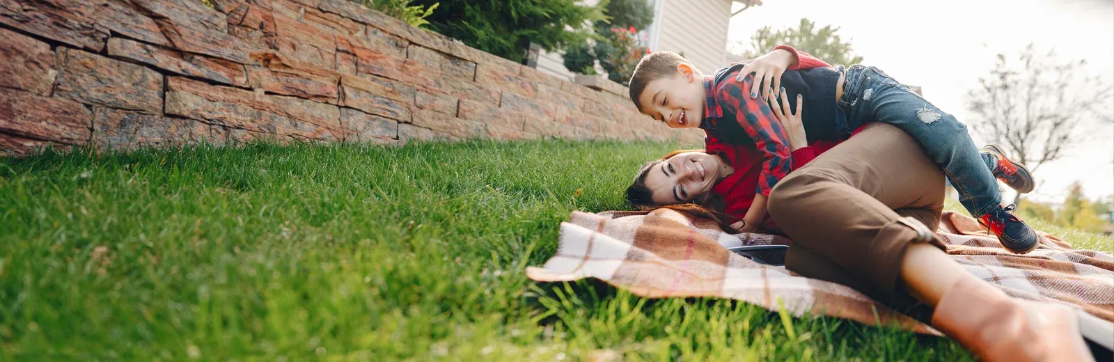 Mother and son laughing outside playing on front lawn